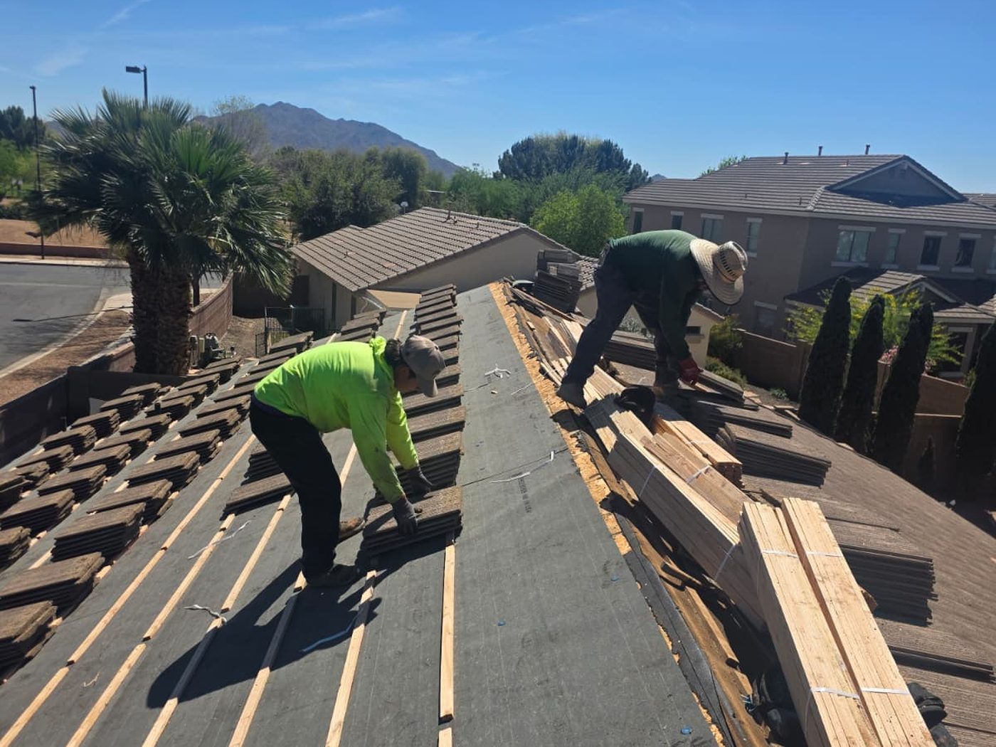 Crew installing tile roofing under Arizona sun